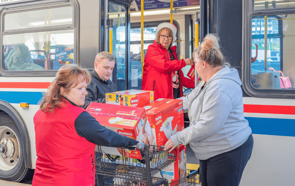 People helping load groceries in a bus